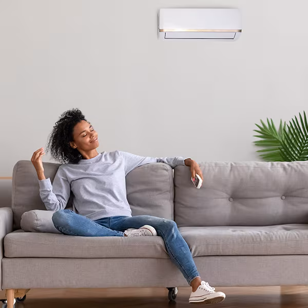 Femme profitant de la climatisation murale