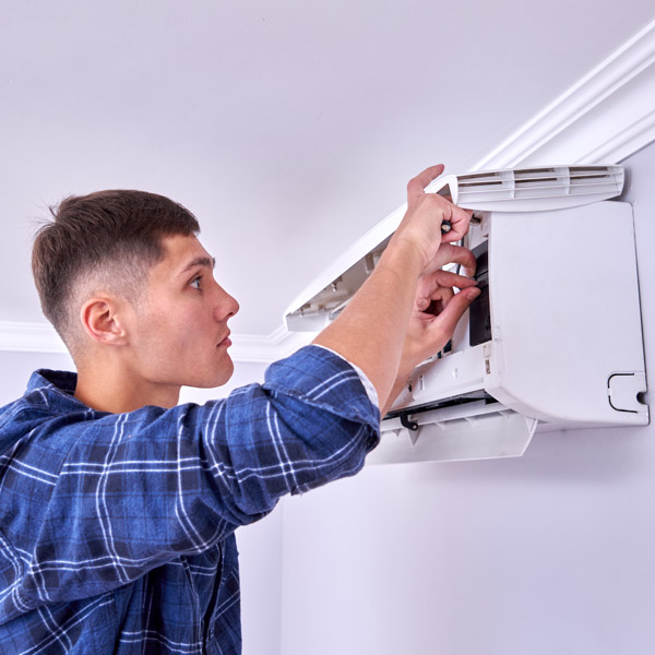 Technicien RGE installant un climatiseur mural